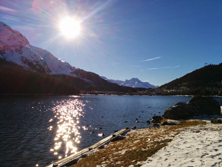 Saint-Moritz con il romantico lago nel centro della cittadina, il più piccolo dell'Alta Engadina, illuminato dal sole in pieno pomeriggio.