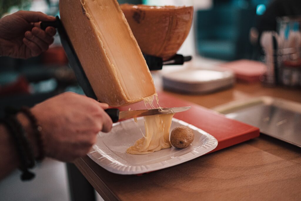 La tipica raclette calda e filante che si accompagna alle patate al cartoccio. Le migliori ricette del mondo svizzero.